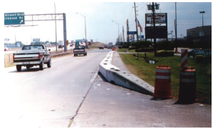 Photo illustrates the use of an end terminal which curves around to the right and downward to the ground at an intersection.