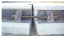 This is a photo of the non-impact side of two sections of low impact barrier. The sections are connected by a steel bar that runs parallel to each device on the back. The steel bar is bolted into place in a fitting.